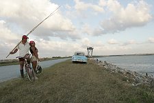 The dam is a popular place for fishing. Old american cars are private means of transport affordable for few Cubans. A bicycle is a much more common occurence. Pinar Del Rio, Cuba, Monday, March 19, 2007.
