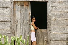 A young girl in the doorway of her hous. In small towns free of tourists the rate of life is quite different. Baracoa, Cuba, Saturday, March 3, 2007.