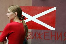 Activist of the pro-Kremlin Nashi (Ours) youth movement with a flag as a background near the organisation headquarters building in Petersburg waits to get on the bus to go to the summer camp. St. Petersburg on Saturday July 14, 2007. Pro-Kremlin Nashi (Ours) youth movement has assembled about 10 thousand young people from all over Russia to a summer camp where they are going to do sports and attend political and socially oriented lectures and training sessions for two weeks.