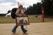 Activist of the pro-Kremlin Nashi (Ours) youth movement from Briansk with the flags of the organisation and Vladimir Putin portrait goes to her delegation location in the Nashi summer camp on Lake Seliger, some 300 kilometres (~180 miles) northwest of Moscow, Sunday, July 15, 2007. Pro-Kremlin Nashi (Ours) youth movement has assembled about 10 thousand young people from all over Russia to a summer camp where they are going to do sports and attend political and socially oriented lectures and training sessions for two weeks.